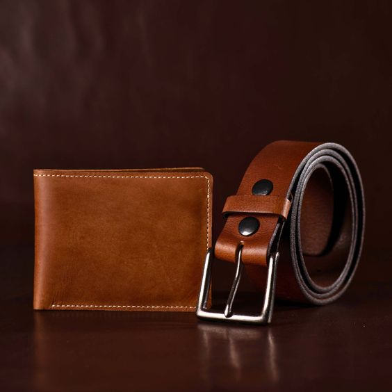 A lifestyle image featuring products made from corrected grain leather, such as belts, handbags, and wallets, displayed in an elegant setting